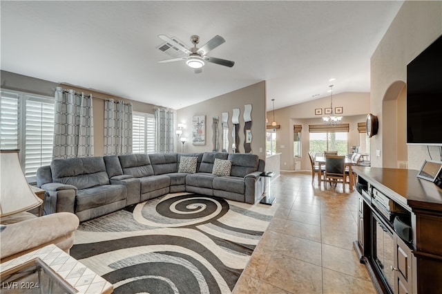 living room featuring vaulted ceiling, ceiling fan with notable chandelier, and light tile patterned flooring