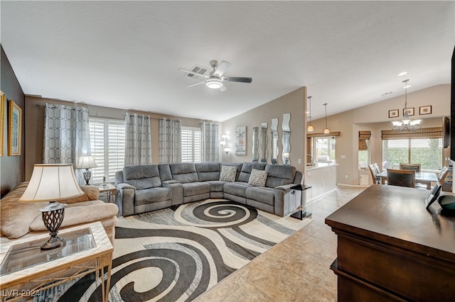 tiled living room with lofted ceiling and ceiling fan with notable chandelier