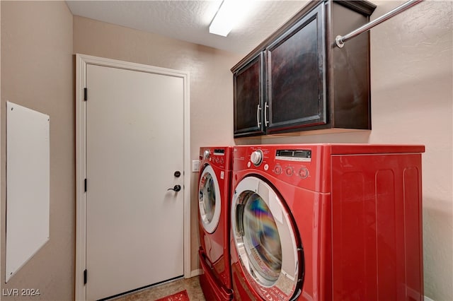 washroom with independent washer and dryer, a textured ceiling, and cabinets