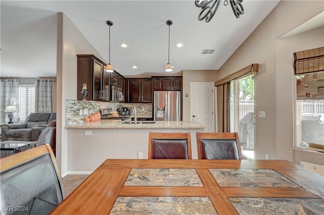 kitchen featuring dark brown cabinets, decorative light fixtures, stainless steel appliances, and a healthy amount of sunlight