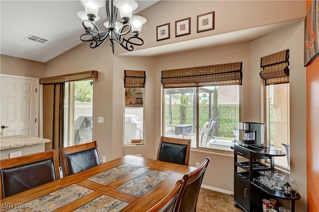 dining area featuring tile patterned floors, a chandelier, and vaulted ceiling