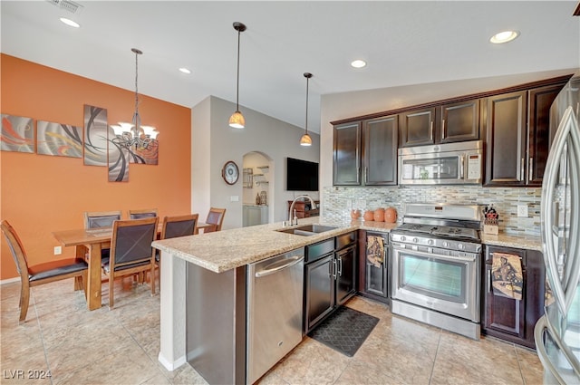 kitchen with stainless steel appliances, sink, kitchen peninsula, and hanging light fixtures