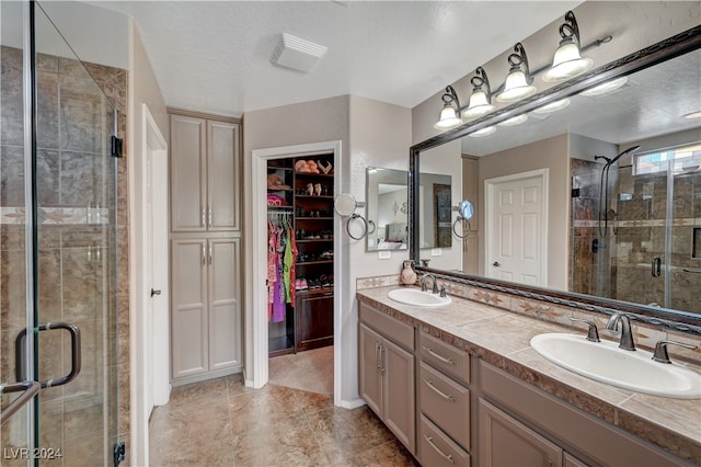 bathroom with vanity, a textured ceiling, and a shower with shower door