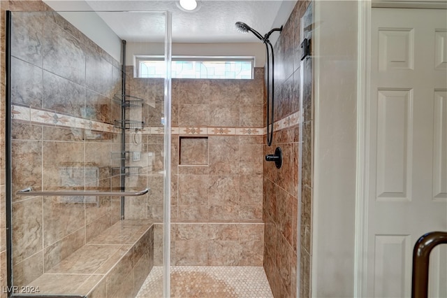 bathroom featuring walk in shower and a textured ceiling