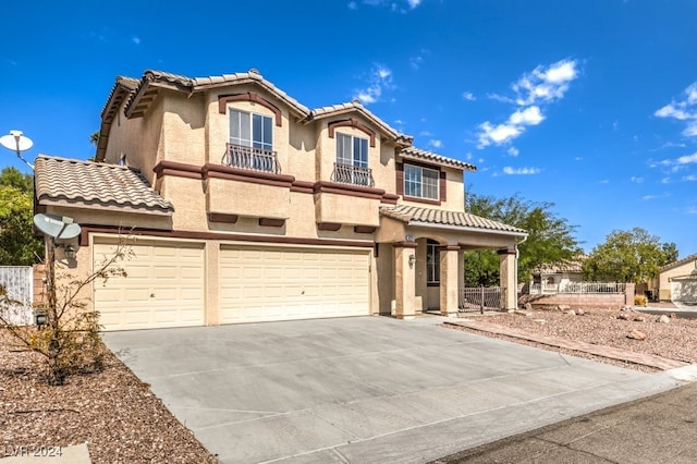 mediterranean / spanish house featuring driveway, a tiled roof, an attached garage, fence, and stucco siding