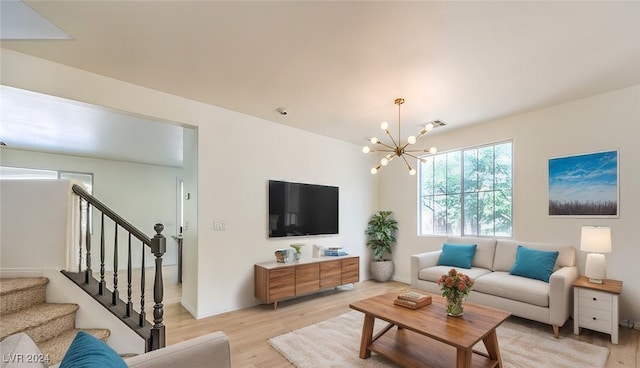 living area with a chandelier, visible vents, light wood-style flooring, and stairs