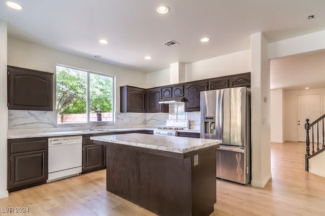 kitchen with dark brown cabinetry, a kitchen island, stainless steel refrigerator with ice dispenser, range, and dishwasher