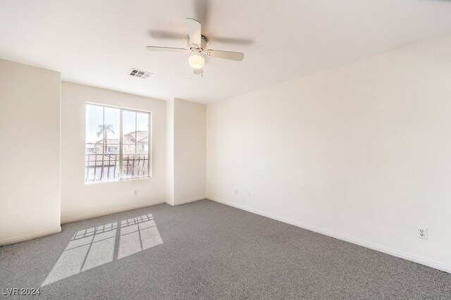 carpeted spare room with visible vents, ceiling fan, and baseboards