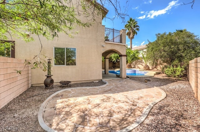 exterior space featuring a fenced in pool, a fenced backyard, a patio, and stucco siding