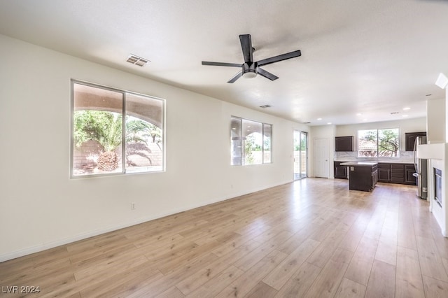 unfurnished living room with visible vents, ceiling fan, light wood-style flooring, and baseboards