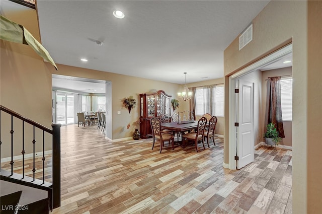 dining area featuring light hardwood / wood-style floors, a wealth of natural light, and a chandelier