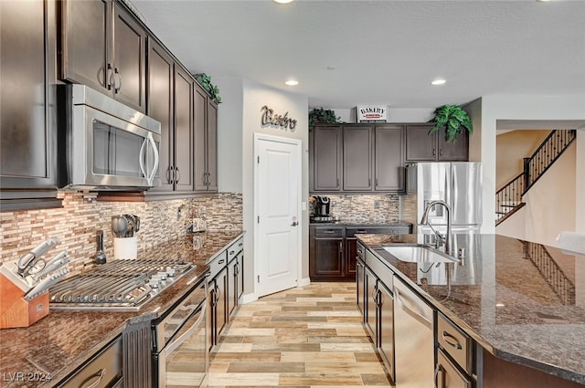 kitchen featuring dark brown cabinets, light hardwood / wood-style floors, sink, and appliances with stainless steel finishes