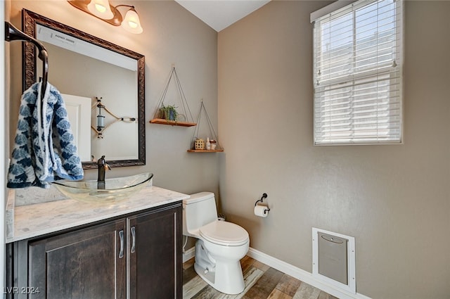 bathroom with hardwood / wood-style floors, vanity, and toilet