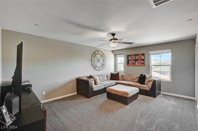 living room featuring carpet, a textured ceiling, and ceiling fan