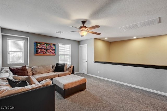 carpeted living room featuring a textured ceiling, a wealth of natural light, and ceiling fan