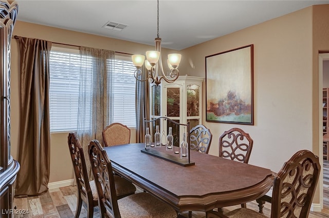 dining area featuring light hardwood / wood-style floors and an inviting chandelier