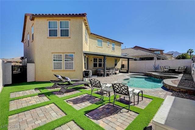 rear view of house featuring a fenced in pool and a patio