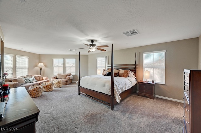 bedroom with multiple windows, carpet, a textured ceiling, and ceiling fan