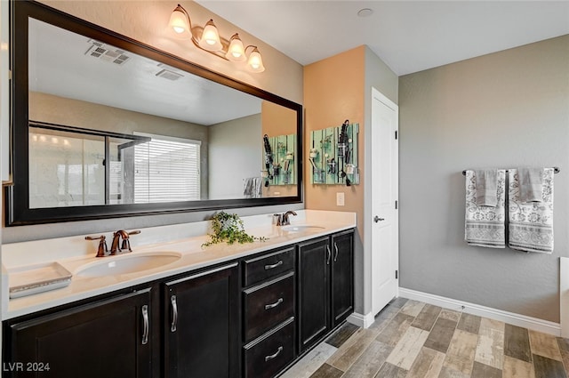 bathroom featuring hardwood / wood-style floors, vanity, and a shower with shower door