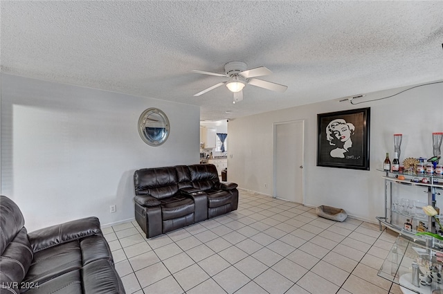 living room with a textured ceiling, light tile patterned floors, and ceiling fan