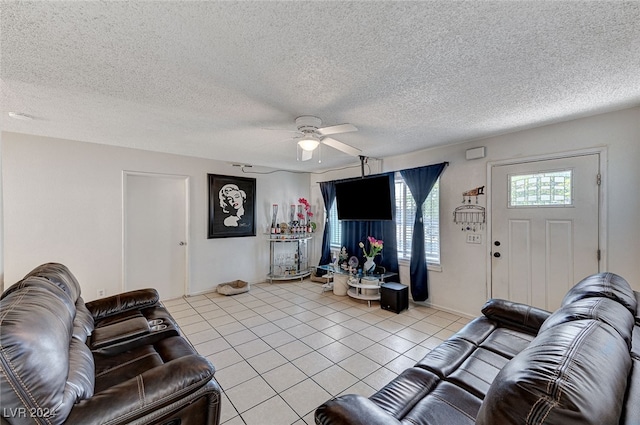 living room with light tile patterned flooring, a textured ceiling, and ceiling fan