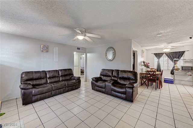 living room featuring a textured ceiling, light tile patterned flooring, and ceiling fan