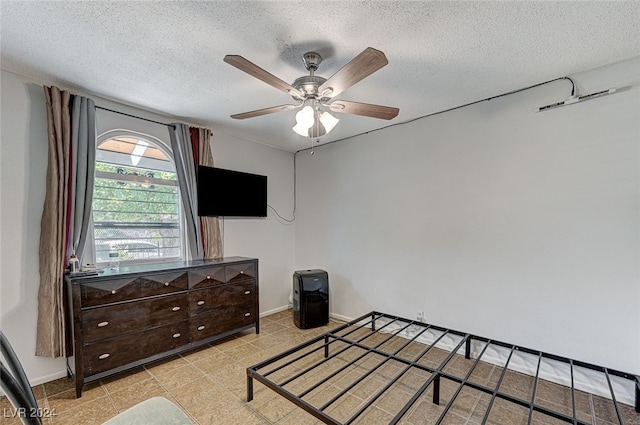 bedroom featuring ceiling fan and a textured ceiling