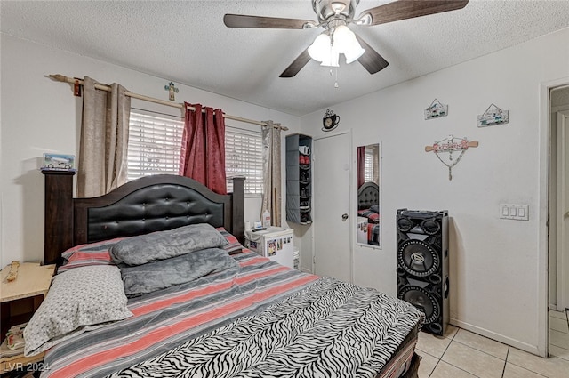 tiled bedroom featuring a textured ceiling and ceiling fan