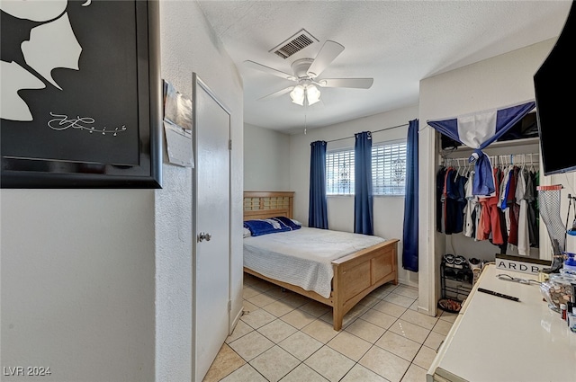 tiled bedroom featuring a textured ceiling, a closet, and ceiling fan