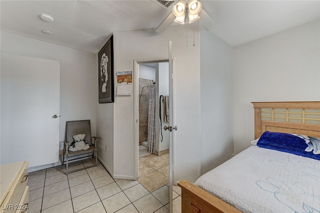 tiled bedroom featuring ensuite bathroom and ceiling fan