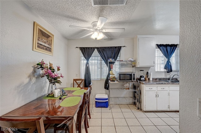 kitchen featuring white cabinetry, light tile patterned flooring, and plenty of natural light