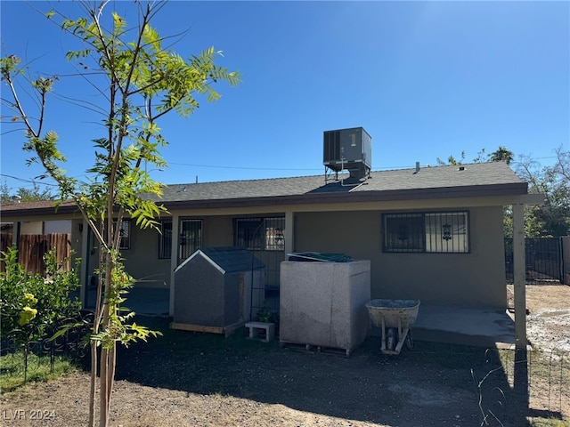 rear view of property with central air condition unit and a patio area