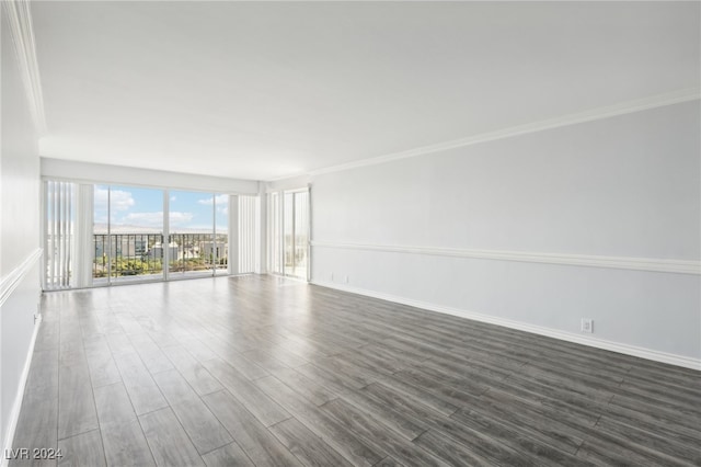 empty room featuring crown molding and dark hardwood / wood-style flooring