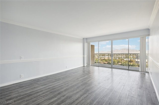 spare room with ornamental molding and dark hardwood / wood-style flooring