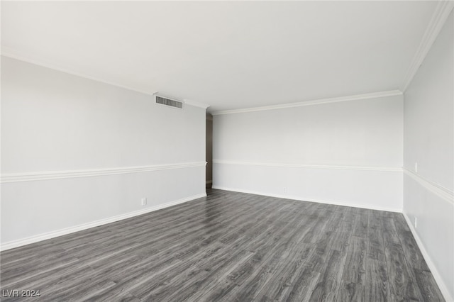 empty room featuring ornamental molding and dark hardwood / wood-style flooring