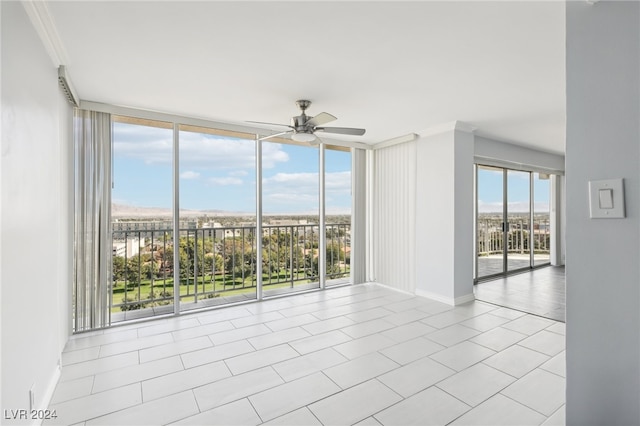 tiled spare room featuring floor to ceiling windows, crown molding, plenty of natural light, and ceiling fan