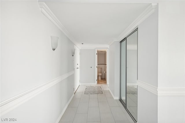 corridor featuring crown molding and light tile patterned floors