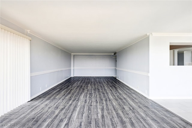 spare room featuring dark wood-type flooring and crown molding