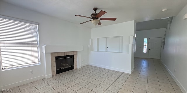 unfurnished living room with ceiling fan, a fireplace, plenty of natural light, and light tile patterned floors