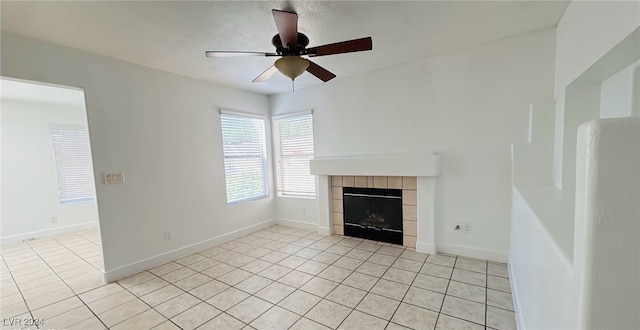 unfurnished living room featuring ceiling fan, light tile patterned floors, and a tile fireplace