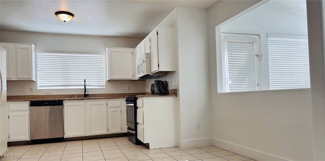 kitchen with light tile patterned floors, white cabinets, stainless steel appliances, and sink