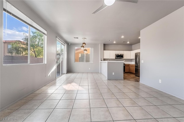 unfurnished living room featuring ceiling fan and light tile patterned floors