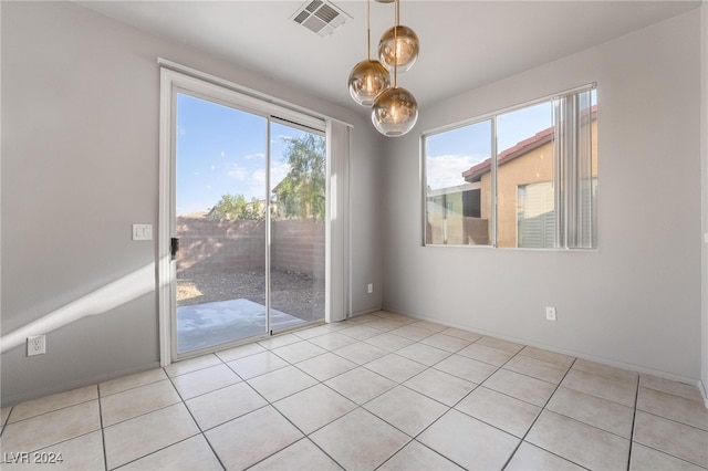 spare room with a healthy amount of sunlight and light tile patterned floors