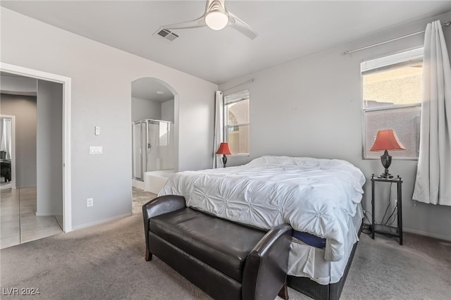 carpeted bedroom with ensuite bathroom and ceiling fan