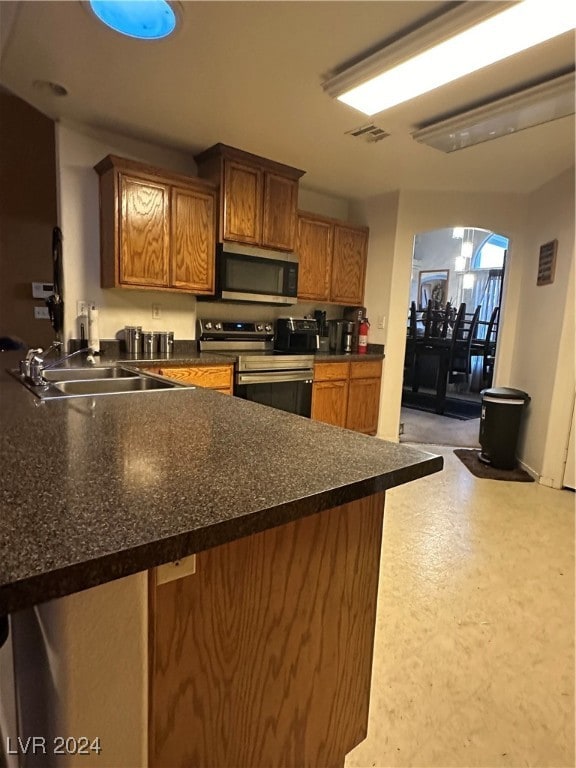 kitchen with stainless steel appliances, kitchen peninsula, and sink