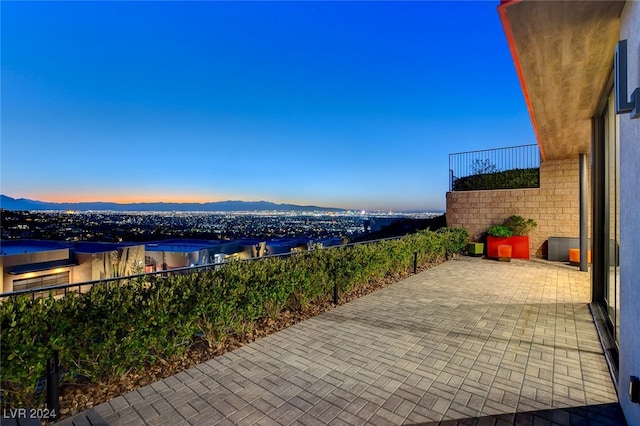 patio terrace at dusk featuring a mountain view