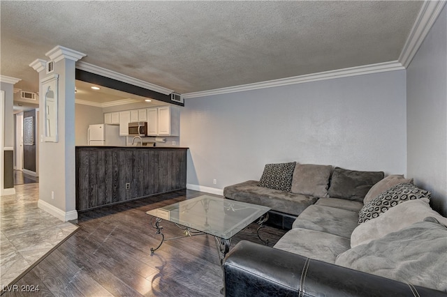 living room featuring ornamental molding, decorative columns, dark hardwood / wood-style floors, and a textured ceiling