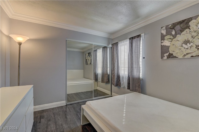 bedroom featuring crown molding, dark wood-type flooring, a closet, and a textured ceiling