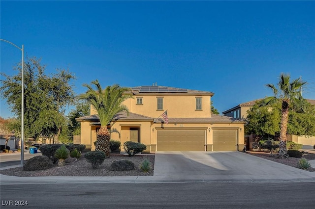 view of front of house featuring concrete driveway, roof mounted solar panels, stucco siding, and a garage