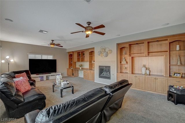 living room featuring light carpet, a tile fireplace, and ceiling fan